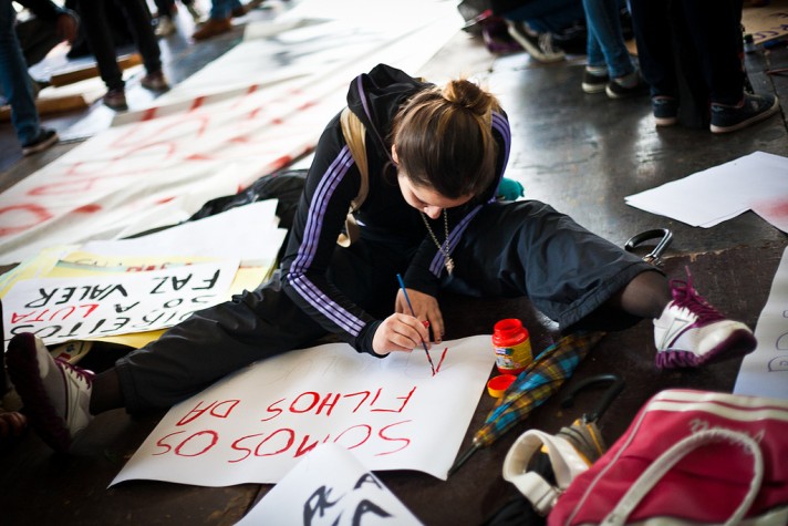Estudante faz cartaz para manifestação